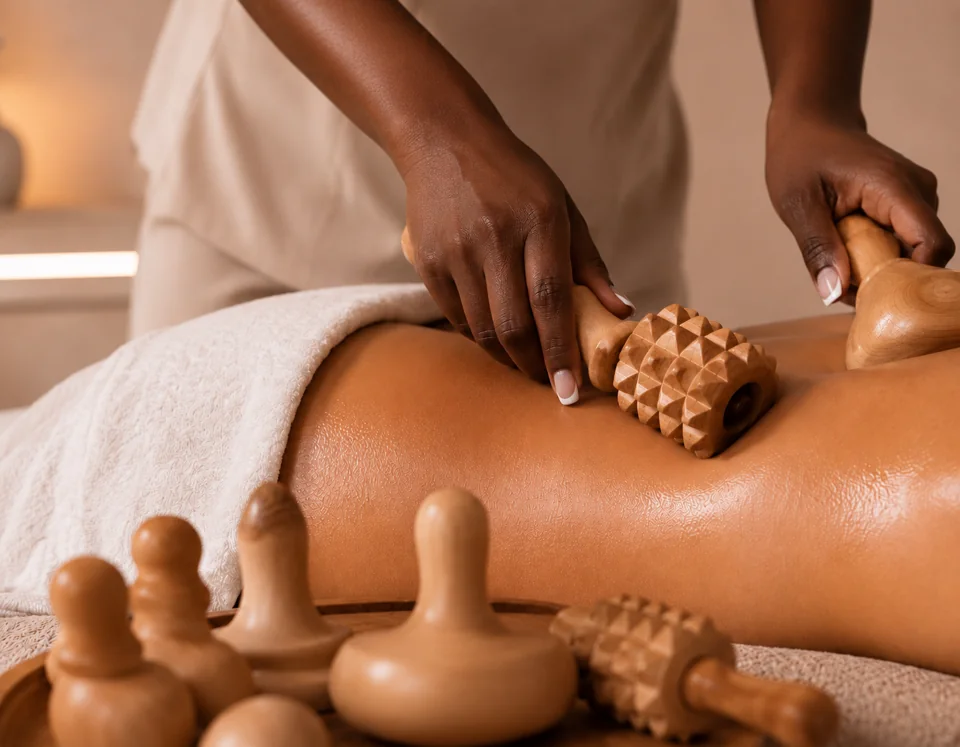 A wooden roller being carefully used during a body treatment.